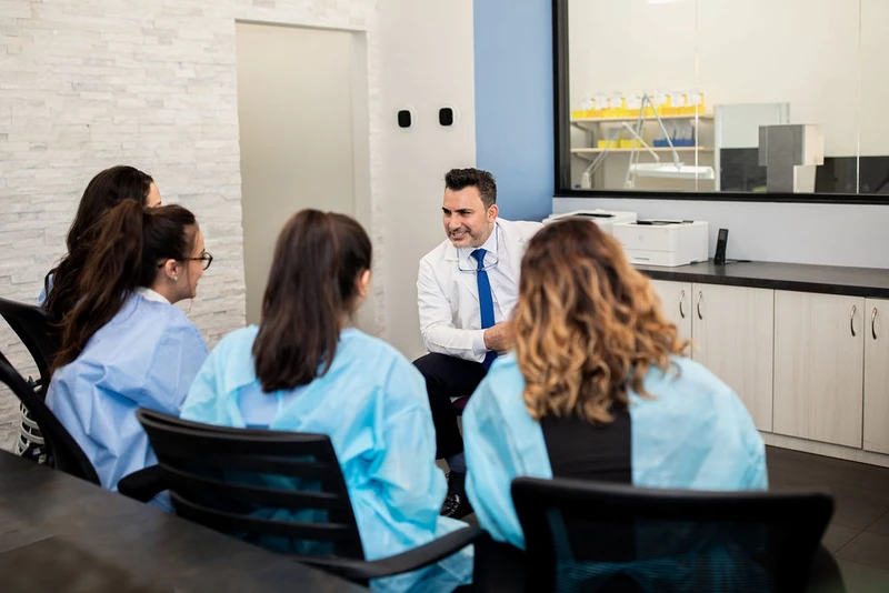 Dr. Bilus Poles meeting with the dental team at Omni Dental in Arlington Heights