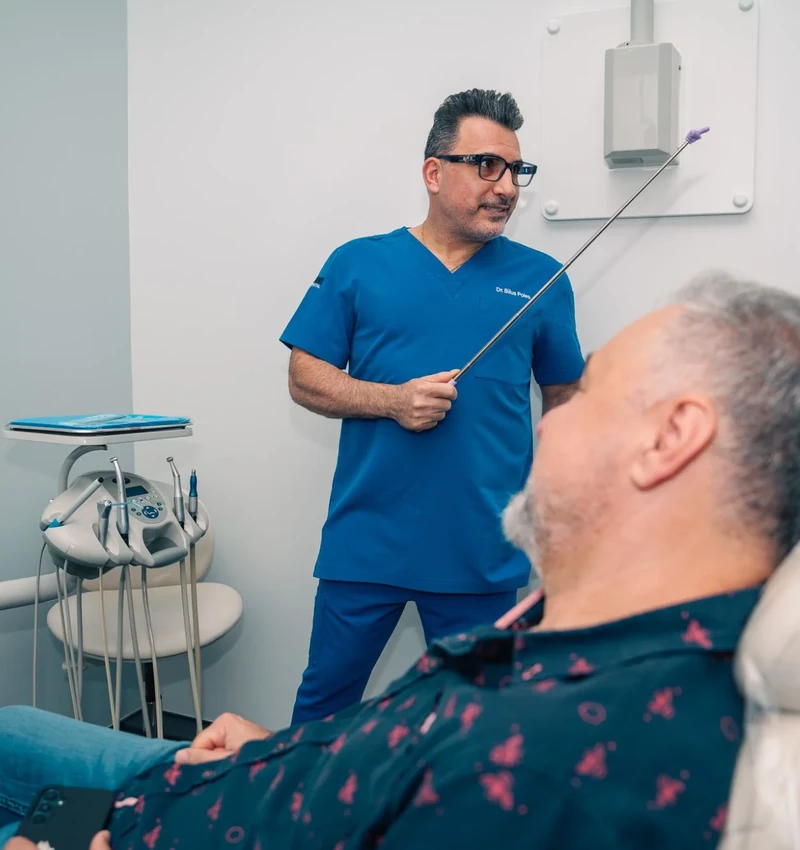 Dr. Bilus Poles explaining a treatment plan to a patient in the dental chair at Omni Dental in Arlington Heights