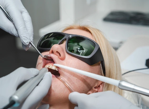 A patient wearing protective glasses during a chairside dental procedure at Omni Dental