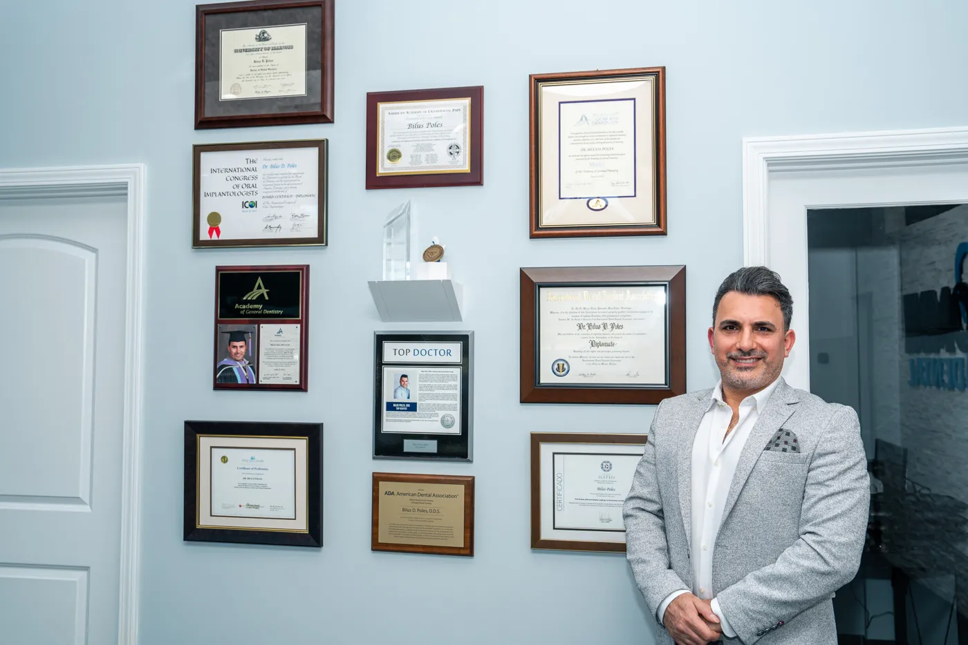 Dr. Bilus Poles with his dental certificates in Arlington Heights, IL