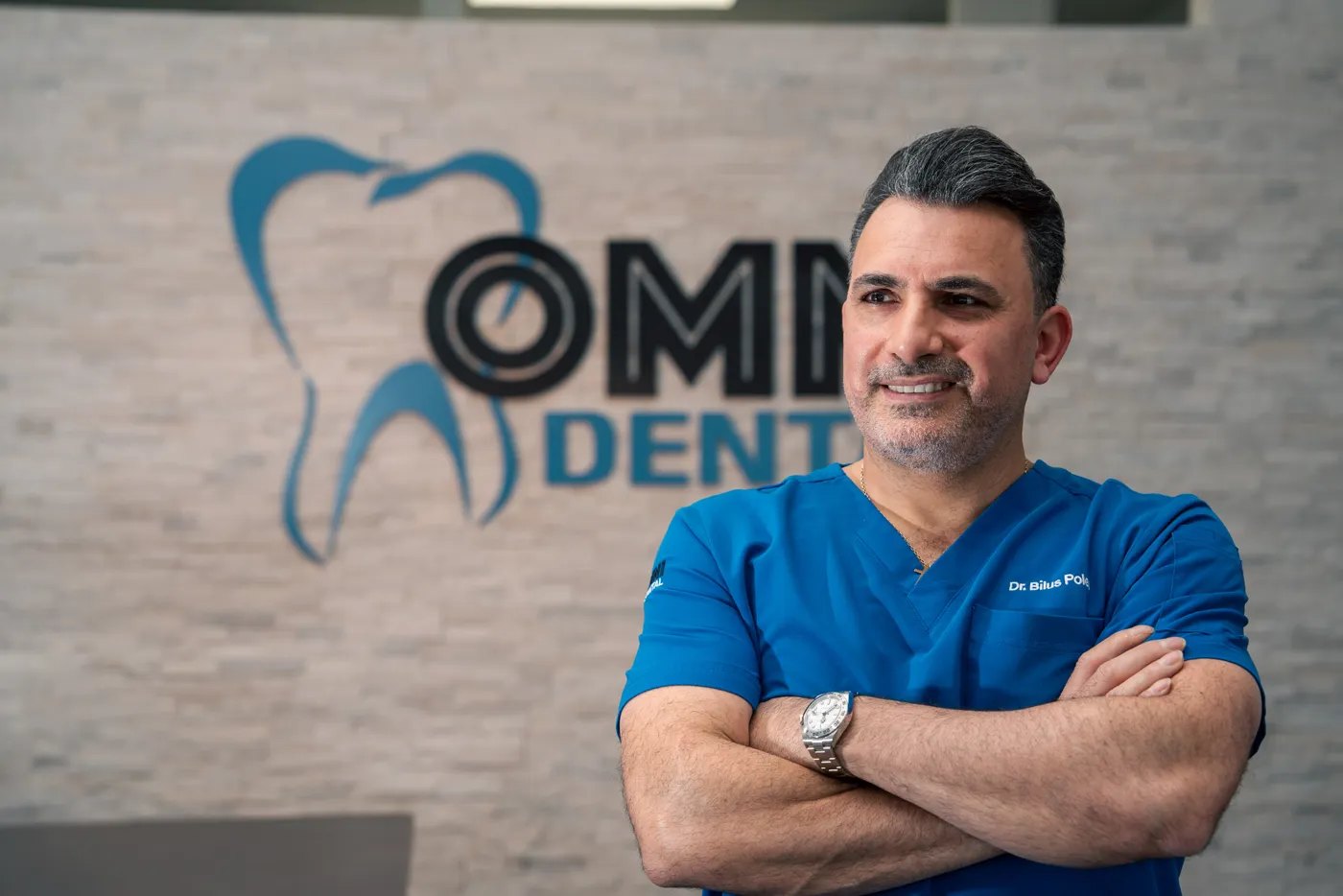 Dr. Bilus Poles in scrubs at Omni Dental in Arlington Heights, IL