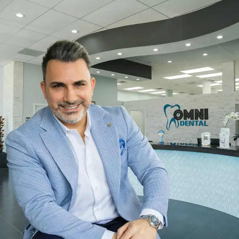 Veneers at Omni Dental in Arlington Heights: Dr. Bilus Poles at the curved front desk inside the office
